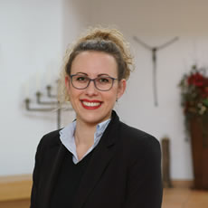 Eine freundliche Bestatterin von Vogt & Kamp Bestattungen Düsseldorf im stilvollen Besprechungsraum des Bestattungshauses.